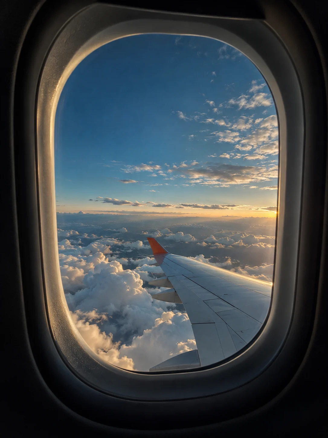 Ala de un avión entre nubes, vista desde una ventanilla